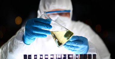 Kimya Lab Bilim Adamı Kısmi Görünüm Fotoğraf. Solunum Laboratuarı Eczacı sıvıcı şişelerinin Sarı Sıvı ile Analiz Edilebilmektedir. Tüp ile Tıp Deneyi. Mavi Eldivenlerde Test Üzerinde Çalışan Kimyager.
