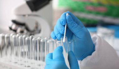 Adli tıp uzmanı, laboratuvar geçmişine karşı adli soruşturma yürütüyor. Elinde DNA örneği ve bir test tüpü ile pamuklu bez tutar. Tets babalık kavramı.