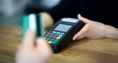 Nakit masa arka plan konseptinde ödeme terminali üzerinden kredi kartı ile ödeme yapan müşteri