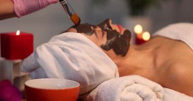 Güzellik salonunda cilt bakımı gören bir kadın. Kozmetik uzmanı yüz derisine maske takıyor. Sağlıklı yüz maskesi konsepti