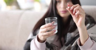Kadının elinde tıbbi tablet ve bir bardak su var. Depresyona karşı antidepresanlar