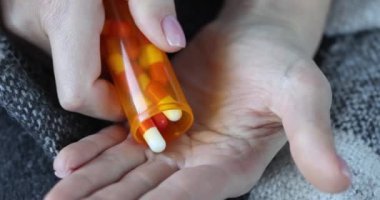 Kişi tedavi için koluna hap döker. Antimikrobiyal antidepresan ya da antidepresan.