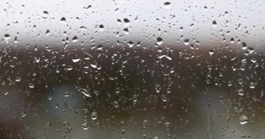 Raindrops on glass on gray background. Rainy season autumn loneliness and depression concept