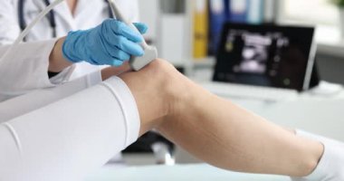 Doktor hastanın dizinin röntgenini çekmek için sonografi kullanır. Muayenehanede ultrason sırasında ortopedi uzmanı..