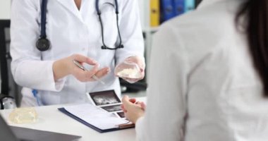 Estetik cerrahın randevusu sırasında silikon göğüs implantlarını inceleyen hasta. Mammoplasty ve plastik cerrah danışma konsepti