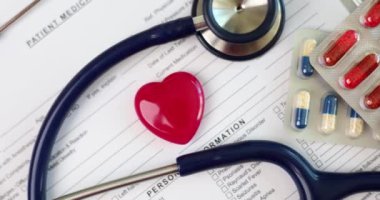 Kırmızı kalpli, steteskoplu ve haplı hasta geçmişi formu. Kardiyoloji ve sağlık ve sağlık sigortası