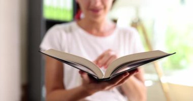 Kadın kitap okuyor ve sayfaları yakından inceliyor. Okuma ve hobiler