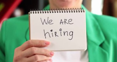 Kadın, işe alacağımız yazıyla birlikte kağıtları elinde tutuyor. İş arama ve iş konsepti