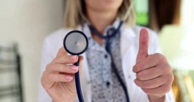 Doktor kardiyolog stetoskop tutuyor ve onaylıyor. Tıbbi muayene önerilir.