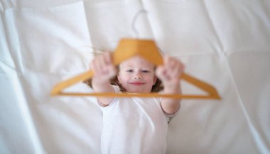 Evde yatakta eğlenen küçük bir çocuğun portresi. Aktif bir çocuktan sonra dinlenen küçük çocuk. Mutlu çocukluk kavramı