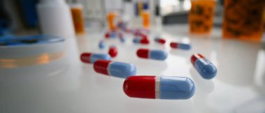 Close-up of red and blue pills on glass surface. Medication in capsules. Pharmacy, antibiotics or vitamins. Medicine, healthcare and treatment concept