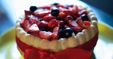 Meyveli ve kremalı tart, şenlikli pasta. Yaz meyveli kek konsepti. Çilekli turta ve böğürtlenli