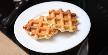 Close-up of delicious belgian waffles on white plate, yummy breakfast. Waffles of dutch, french and belgian foods