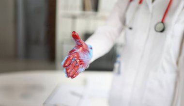 Close-up of doctor in white gown giving bloody hand for handshaking. Illegal medicine, malfeasance and crime concept