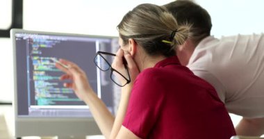 Programcılar ofisteki monitöre bakan kod yapısını tartışıyor. Proje yöneticisi ve mühendis dijital verileri kontrol ediyor. Yazılım geliştirme teknolojisi