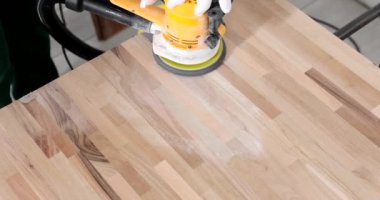 Parkeyi öğütme makinesiyle işliyor. Eldivenli profesyonel bir işçi düz tahta zeminde ağır çekimde ekipman kullanıyor.