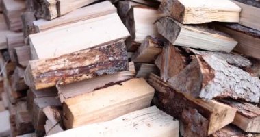 Köy avlusunda hazırlanmış odun yığını. Şömine yakmak ve yemek pişirmek için doğal kereste malzemeleri. Ağaç gövdesi dışarıda parçalanmış.