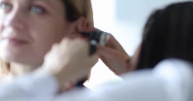 ENT conducts medical examination of ear to woman. Hearing test in adults concept