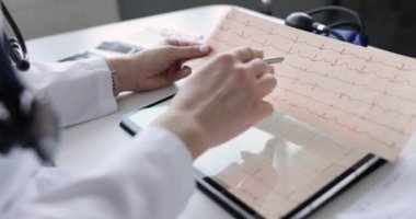 Doktor kalp krizinden sonra hastanın elektrokardiyogramını inceler. EKG teşhisi ve sağlık kontrolü. Tıbbi konsept için tıbbi muayene kardiyografı.