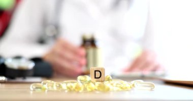 Doktor, D vitamini içeren sarı jelatin kapsülleri yavaş çekimde tavsiye ediyor. Raşitizm önleme kavramı