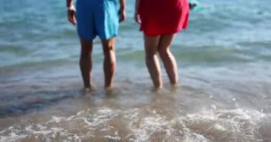 Happy married couple are jumping in water at sea. Summer holiday tourism travel on ocean