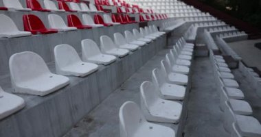 Stadium plastic chairs white red closeup. Empty grandstand with red and white chairs in a racing rally or football stadium