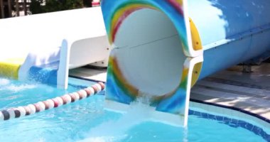 Person flies out of water pipe in water park. Fun and slides in the water park concept