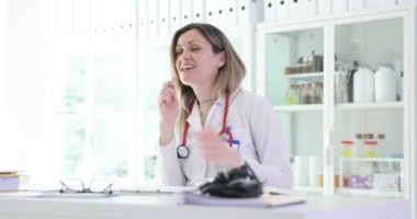 Mutlu kadın doktor iş yerinde şarkı söylüyor. Pozitif tıp çalışanı hasta atamasından önce iyi titreşimler verir. Sağlık Hizmetleri Tesisi