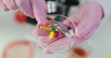 Bilim adamı kimyasal analiz için kapsüller hazırlıyor. Araştırmacı aktif ilaç bileşenlerini belirlemek için tabletlerin analizini yapıyor.