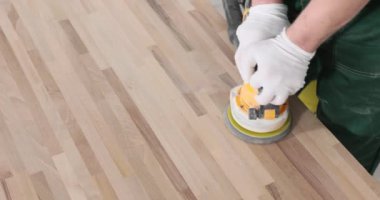 Tecrübeli bir tamirci, ahşap masa yüzeyini parlatır. Profesyonel teknisyen masanın kenarlarını ve köşelerini dairesel hareketlerle parlatıyor