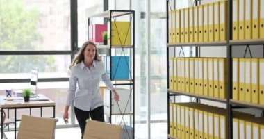 Kadın çalışan sevinç atlayışları yaptı ve ofiste dolaştı. Bayan işçi, projeyi başarıyla bitirme konusunda mutluluk ve gurur ifade ediyor.