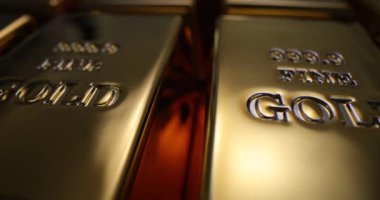 Banka deposunda parmak izi olan parlak altın külçeler. Düşük riskli ve karlı koşullarda değerli metallere yatırım kavramı