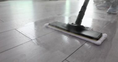 Etkili sonuç için zemini buhar paspasıyla temizleme ve sterilize etme işlemi. Kişi, evdeki temizliği korumak için modern aygıt kullanır