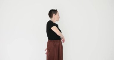 Kadın, beyaz arka planda hareket eden kollarını ısıtmaya çalışıyor. Sportif kadın spor kulübünde etkili bir egzersiz yapmaktan hoşlanıyor.