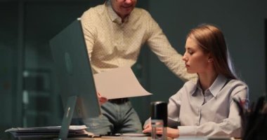 İş arkadaşı, akşam ofisindeki kızgın patroniçeye yanlış bilgilerle gelen raporlar gösteriyor. Kızgın kadın yönetici, iş arkadaşına buruşmuş kağıt çarşaf fırlatıyor.