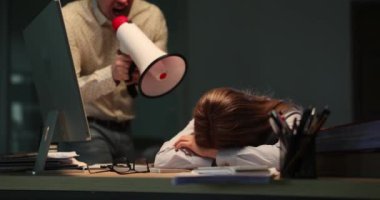 Ofis işyerindeki uyuyan kadın işçiye megafonla bağıran patron. Yorgun kadın sekreter gece yarısı bilgisayar klavyesinde yazı yazıyor.