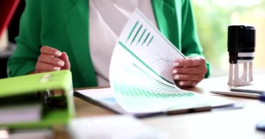 Menajer belgeleri grafiklerle inceliyor ve üzerine 4K yavaş çekim damgası yapıştırıyor. Belgelendirme kavramı sertifikası