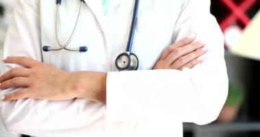 Doktor steteskop ile kollarını kavuşturdu. Yakın çekim 4K film ağır çekim. Tıp mesleği kavramı