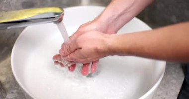Adam ellerini banyo lavabosunda sabunla yıkıyor. Yakın çekim 4K film yavaş çekim. El hijyeni kavramı