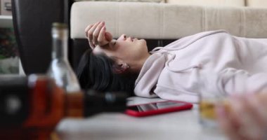 Sarhoş kadın bir şişe alkolle yerde yatıyor. Depresyon ayrılığı ve boşanma kavramı