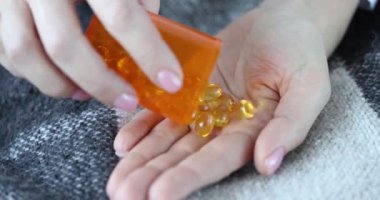 Tıbbi haplar, yağ asitleri, Omega 3 vitaminleri, avuç içine dökülür. Tıbbi kapsüller sarı şeffaf renk konsepti