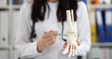 Doktor bacak ve parmak iskeletinin anatomisini gösteriyor. Ayak ve ayak sakatlığı konsepti