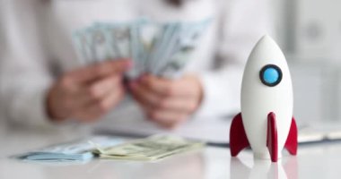 İş kadını roketin arka planına karşı kişisel paraya güvenir. İş konseptinde hızlı bir başlangıç