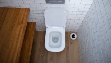 Clean toilet bowl in a toilet with white tiles, top view. Cleaning and disinfection of plumbing at home