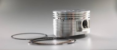 Motor pistonunun gümüş mekanik kısmı gri arka planda, yakın plan. Yeni parlak oto tamiri, onarım