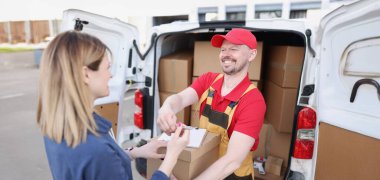 Sokaktaki mutlu kadın kuryeden bir paket alır. Salgın sırasında hedeflenen mal teslimatı