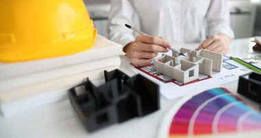 Stüdyoda 3 boyutlu ev modelini gösteren kadın tasarımcı. Daire yenileme konsepti için mimari planlar