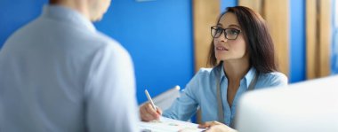 Ofisteki bir kadın bir adama diyagramı olan, yakın plan, bulanık bir raporu açıklar. Yıllık raporlama, veri analizi, düzeltme