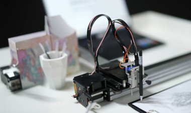 3d printer draws with a pencil on paper, close-up. A modular device with artificial intelligence. Reproduction of the digital model