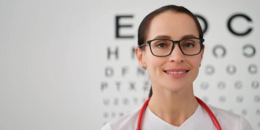 Portrait of female doctor ophthalmologist with glasses, close-up. Eyesight tests. Professional selection of lenses for vision